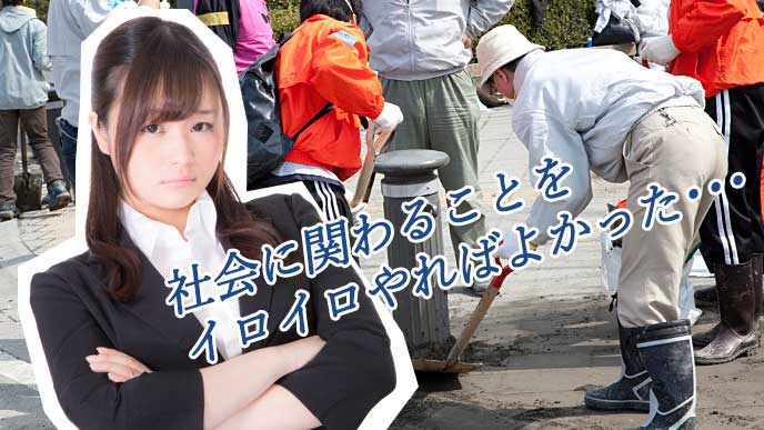 腕を組んで後悔している就活生の女性と街を清掃しているボランティア