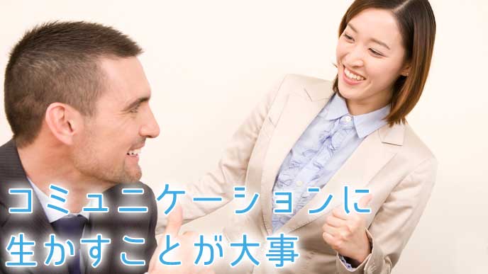外国人の男性と会話している女性社員