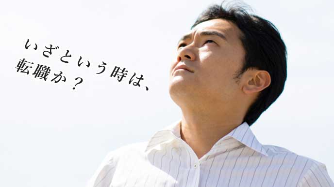 疲れた表情で空を見上げているサラリーマン