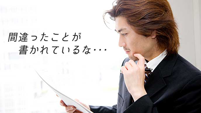 書類を見て険しい表情をしているビジネスマン