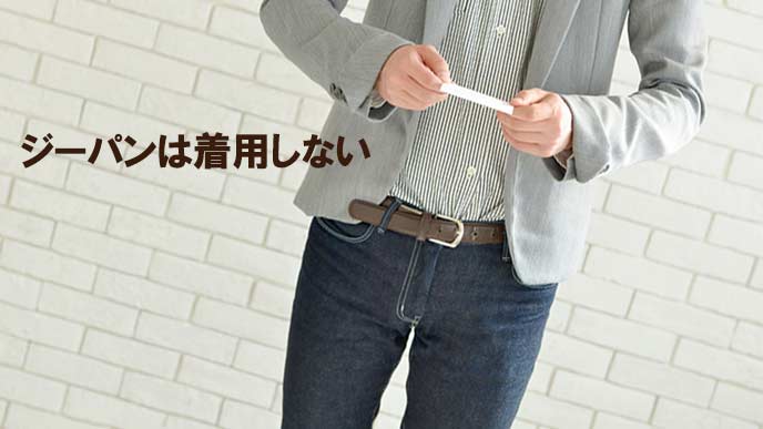 ジーパンをはいて名刺を渡す男性