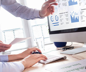 グラフを見ながら業績を分析する記者