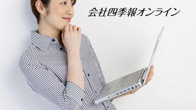 ラップトップを片手に持って考える女性