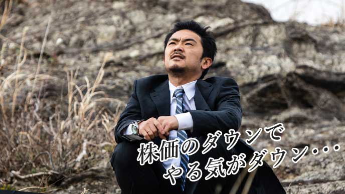 外で座りながら考え込むビジネスマン