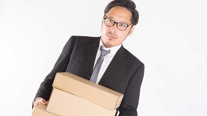 段ボール箱を抱え異動する公務員