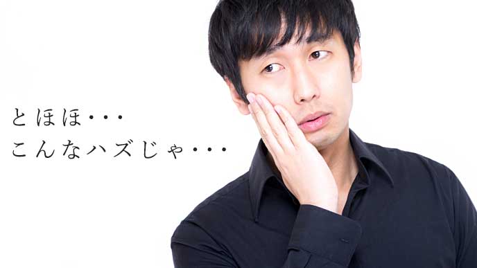頬に手を当てて後悔している男性