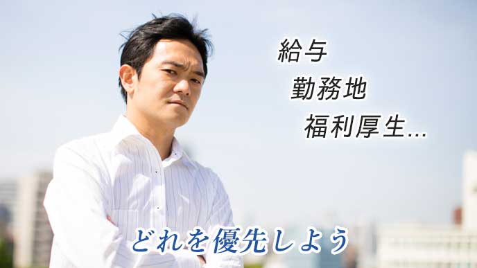 腕を組んで考えている就活生