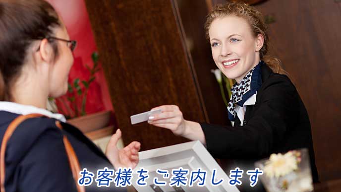 お客様の対応をしているホテルのフロント係