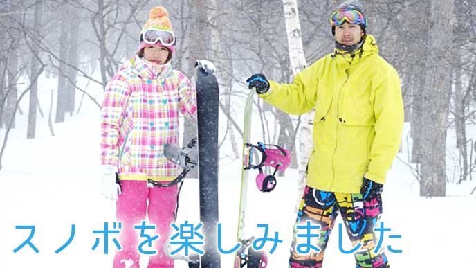 スキー場でスノボを立てている男女