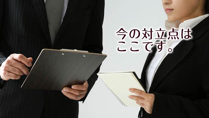 司会に議論の争点を説明する書記