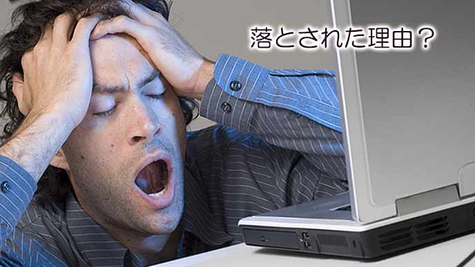 欠伸しながら落とされた理由を考える男性
