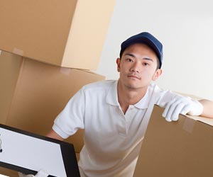 荷物の前で書類を見る若者