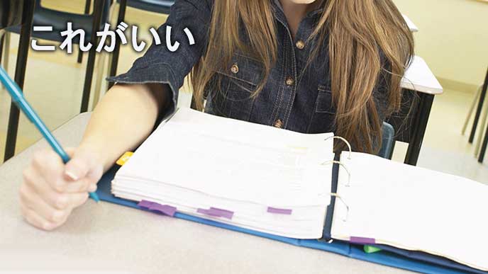 ファイリングされた企業情報を調べる女子大学生