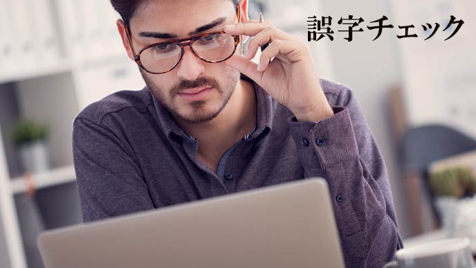 ラップトップの画面を見つめる男性