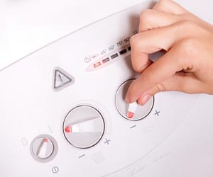 給湯器のつまみをいじる女性