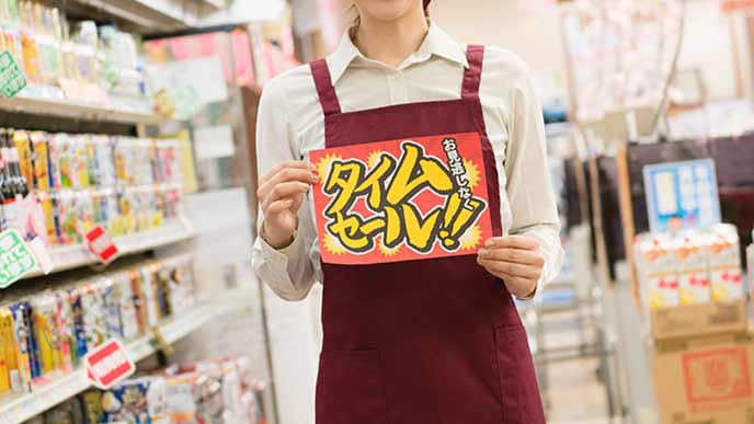 タイムセールの告知をするスーパーの店員