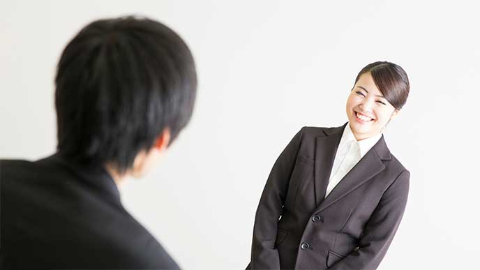 直属の上司に挨拶をするスーツを着た若い女性