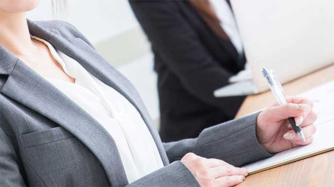 上司の指示をメモしてる新入社員
