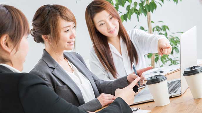先輩から仕事を教えてもらってる女性新入社員