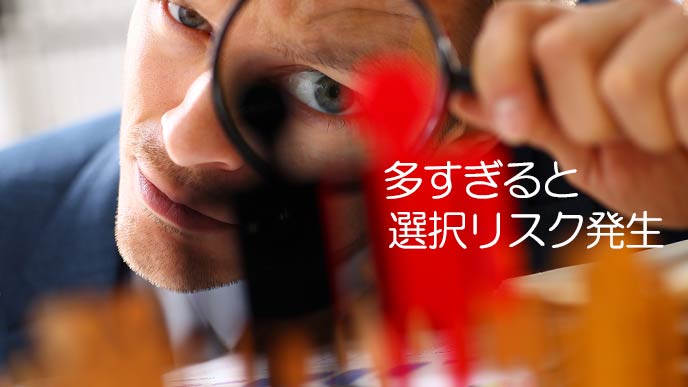 虫眼鏡で駒を見つめる男性