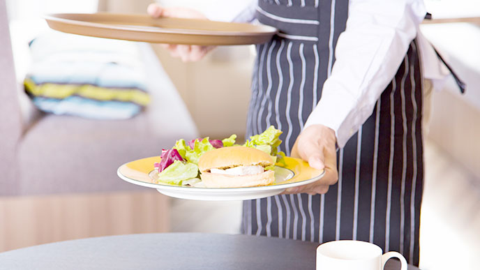 料理を運ぶカフェの定員