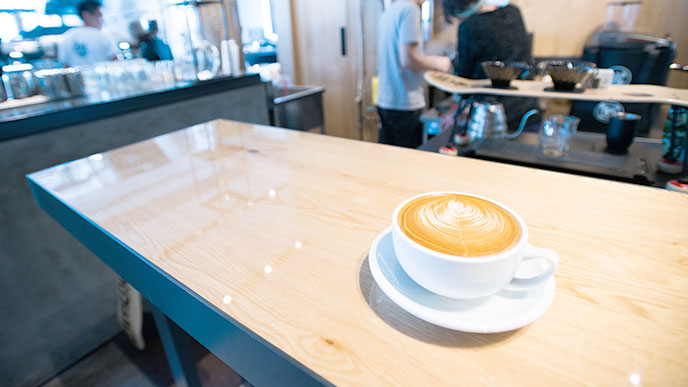 テーブルの上にあるカフェアートがされてるエスプレッソ