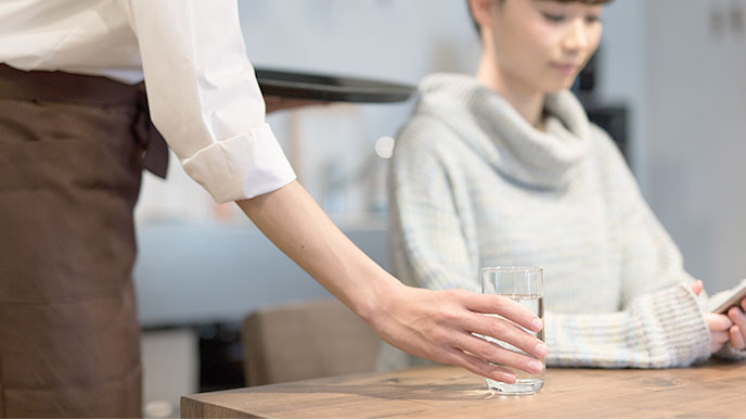 お冷を出すカフェの店員