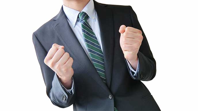 ガッツポーズをしてるスーツを着た男性