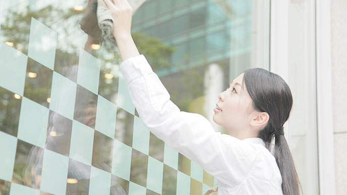 お店の外面を拭く女性