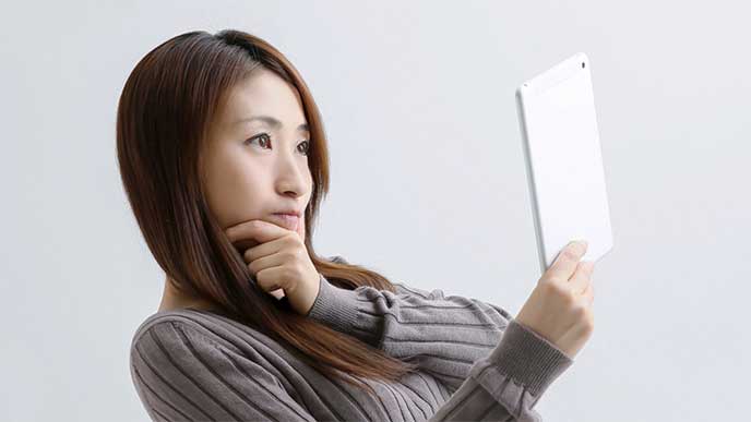 タブレットを使って会社情報を調べてる女性