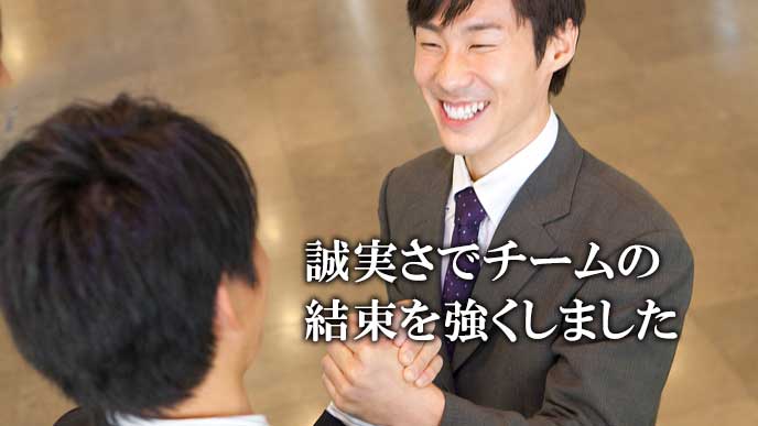 同僚と手を組んで笑顔のビジネスマン