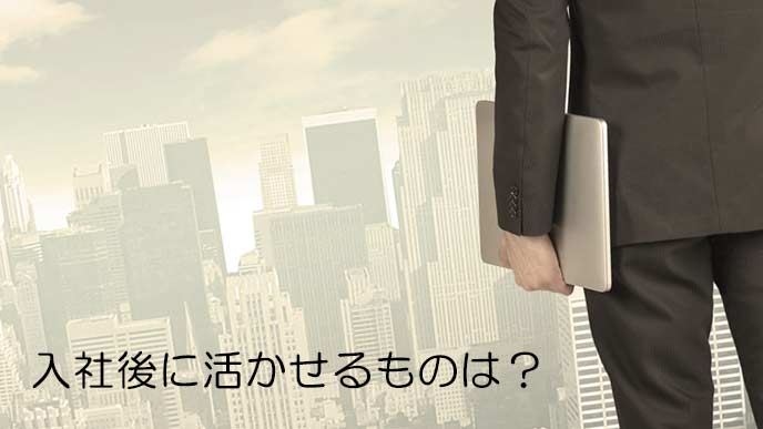 ラップトップを持ってビジネス街を見つめるビジネスマン