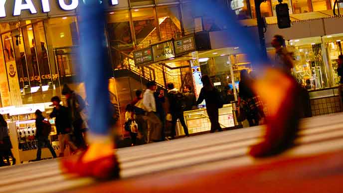 夜の交差点を行きかう人々