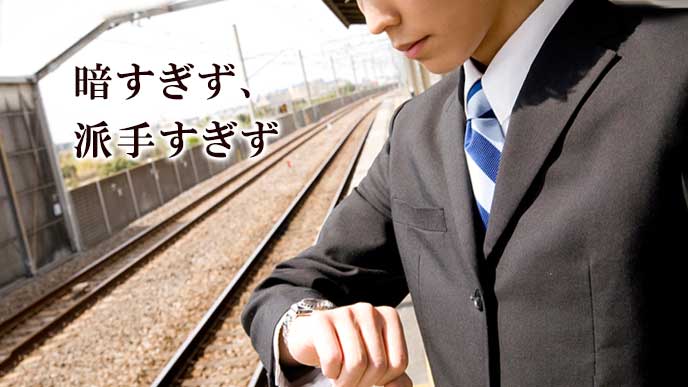 ホームで電車を待つスーツ姿の男性