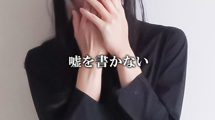口を手で塞ぐ女性
