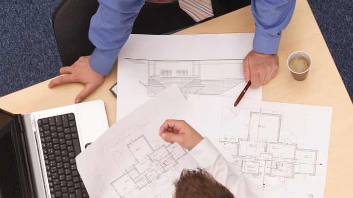 設計図を見ながら打ち合わせするビジネスマン