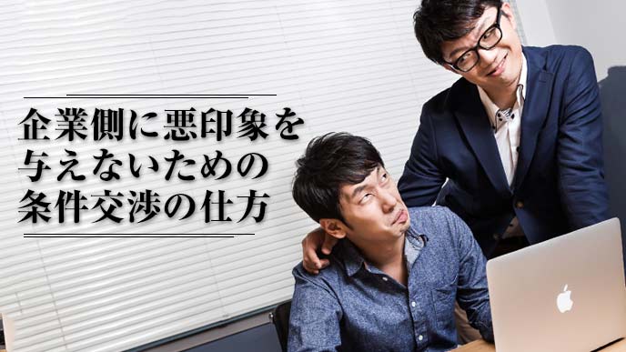 上司と部下がパソコンを見ながら会話している