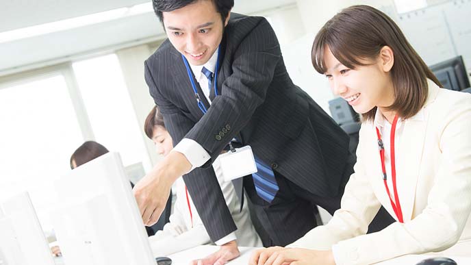 他の社員の業務をサポートする男性社員