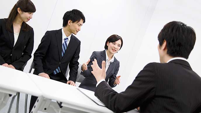 集団面接で面接官と話をしてる女性就活生