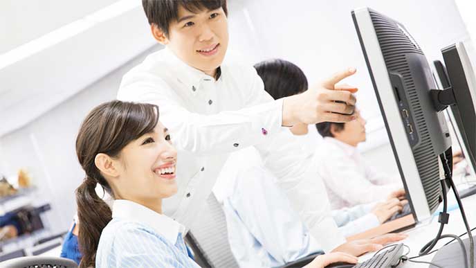 先輩社員から新人教育を受けている女性