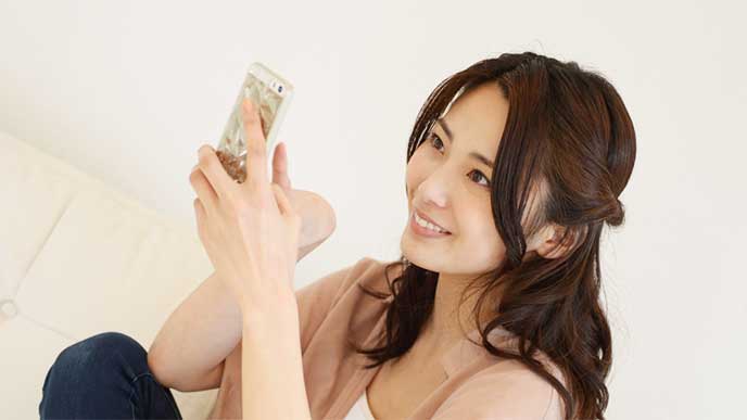 スマホを使ってブログを更新してる女性