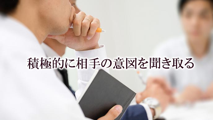 相手の話に耳を傾けながら考える男性