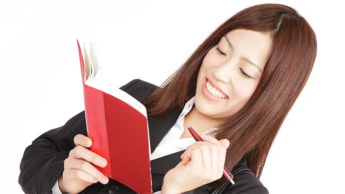 就活日記をつけてるリクルートスーツを着た女性