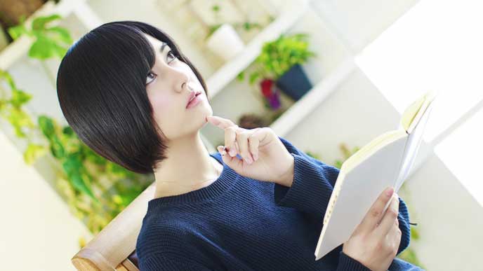 ノートを手に考えてる女性