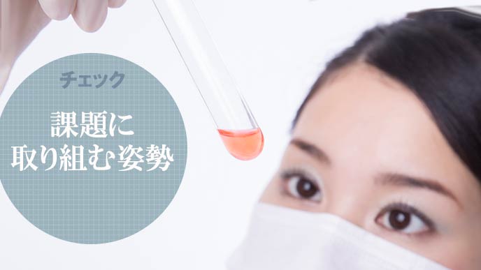 試験管を見つめる女性研究者
