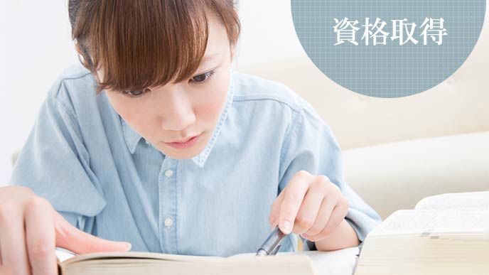 テキストを読みながら勉強する女性