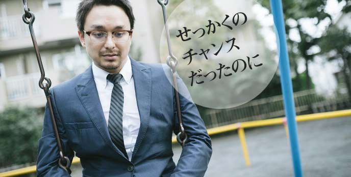 ブランコに座りながら落ち込んでいる会社員