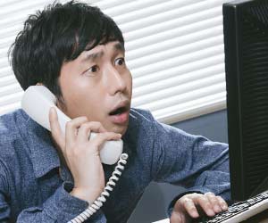 不安な顔でパソコンをのぞきこむ男性職員
