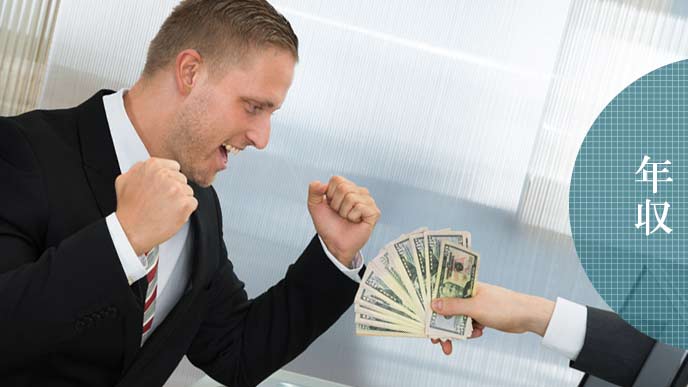 紙幣を差し出されてガッツポーズの男性