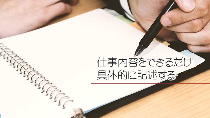 手帳に文字を書き込んでいる男性サラリーマン